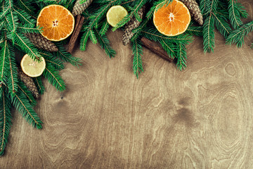 Christmas frame made with twigs, cones, walnuts, cinnamon and citrus isolated on wooden background