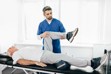 kinesiologist doing therapeutic exercises for an elderly patient. Kinesitherapy at the medical...
