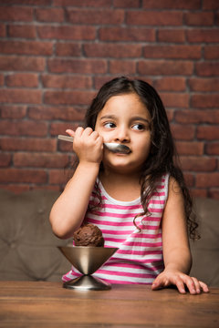 Indian Small Girl Eating Ice Cream In A Bowl