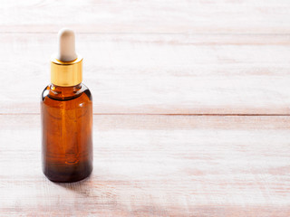 Natural cosmetic oil in bottle on a brown wooden background
