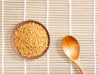 Fenugreek in clay plate and spoon. Indian cuisine, ayurveda, naturopathy, modern apothecary concept