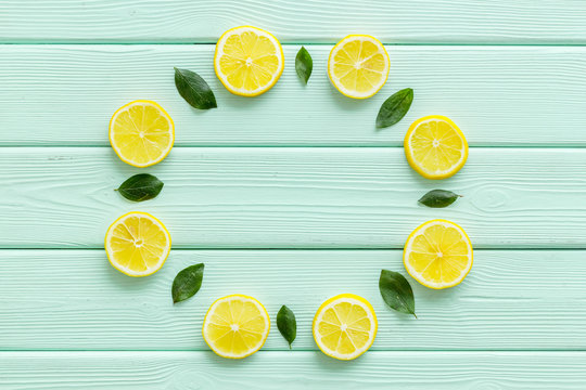 Lemon and leaves circle mockup on green wooden background top view copy space