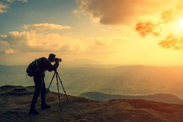 A male photographer travels and shoots landscapes at sunset