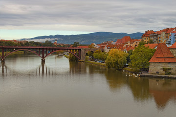 Picturesque autumn landscape view of Maribor. Old Bridge over Drava River and Water Tower at the riverside. They are one of the major tourist attractions of the city. Maribor, Slovenia