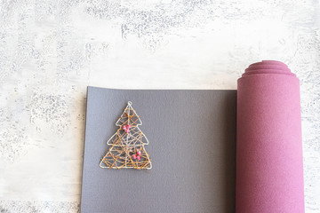 Open sport mat with Christmas tree. Best gift for active people concept.Yoga xmas background. Copy space