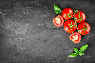 Fresh tomatoes with basil on dark stone table top view. Vegetables tomato with ketchup in bowl on board. - obrazy, fototapety, plakaty