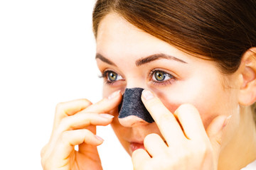 Woman applying pore strips on nose