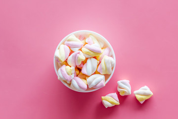 Fluffy dessert. Marshmallows in plate on pink table top view copy space