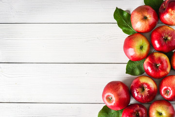 Fresh red apples on white background top view. Green apple leaves and fruits copy space.