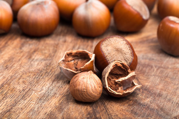 close up of hazelnuts on wooden table .