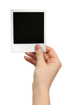 female hand holding polaroid frame on white background
