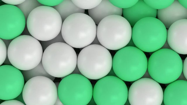 Animated close up top view and flying over pile of a lot of white and green ping pong or table tennis balls lying in large container or as if moving on conveyor belt.