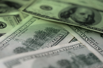 One hundred dollar bills on a dark surface close-up. Toned money background