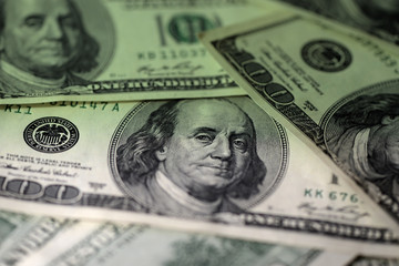 One hundred dollar bills on a dark surface close-up. Toned money background