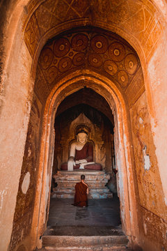 A Monks of Buddhism come to respect and make meditation in ancient buddha   a Buddhist temple located in  ,with sunlight ray Bagan, Myanmar background.