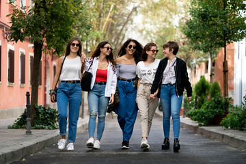 Five female friends walking in the street