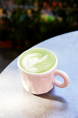 Ceramic cup of matcha latte with beautiful foam on grey background.