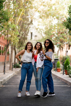 Three female friends standing in the street