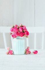 Bouquet of pink roses in blue ceramic vase. Postcard motif.