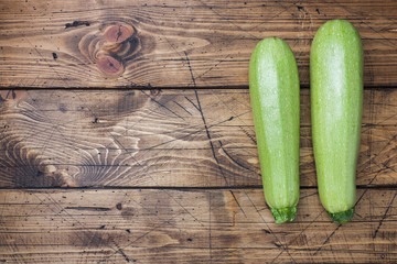 Fresh raw zucchini ready to eat on wooden background with copy space.