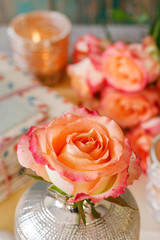 Single rose in modern golden vase, vintage letters and old papers around.