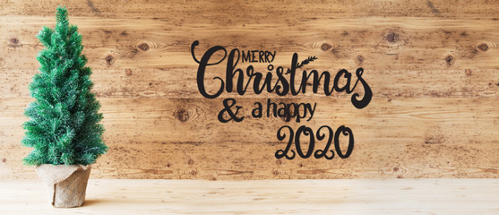 Brown Wooden Background WIth English Calligraphy Merry Christmas And A Happy 2020. Green Christmas...