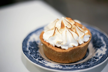 Lemon meringue tart on table in sweet cafe.