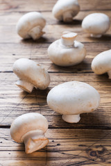 Fototapeta na wymiar Fresh mushrooms champignons on a wooden background. Close-up Space for text.