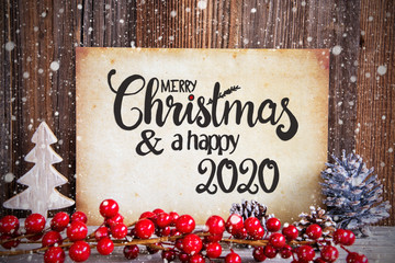 Fototapeta na wymiar Paper With English Text Merry Christmas And Happy 2020. Christmas Decoration And Wooden Background With Snow