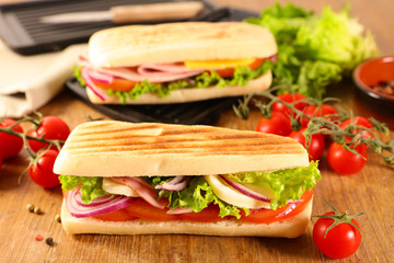 panini, sandwich bread with tomato, lettuce, onion, ham and cheese