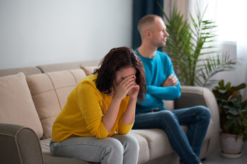 sad wife and husband, angry couple in bedroom. unhappy couple concept. usband and wife are sitting...