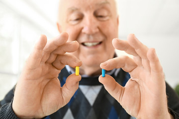 Elderly man with pills at home