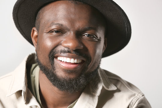 Portrait of happy African-American man on grey background