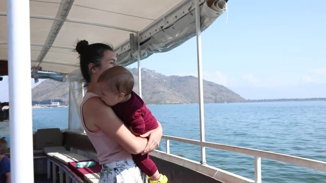 Mother with baby in ferry boat floating in blue Adriatic Sea