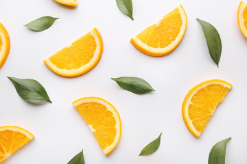 Fresh orange slices with leaves on white background