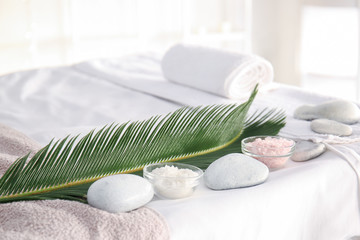 Sea salt with spa stones and tropical leaf in beauty salon - obrazy, fototapety, plakaty