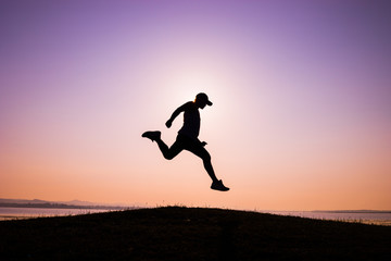 The silhouette of Asian men trail running, the sky at sunrise running in the mountains, lifestyle