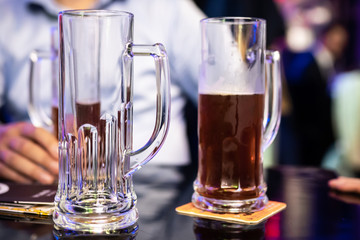 Man sitting at a bar with some of beer pints on the table.
