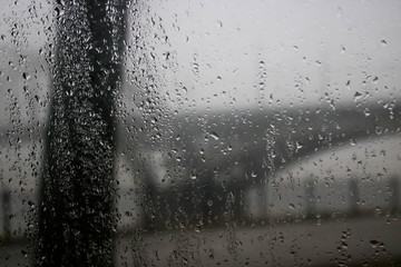 Driving a car under the bridge in heavy rain. Road, traffic, lights, crossing bridges view through...
