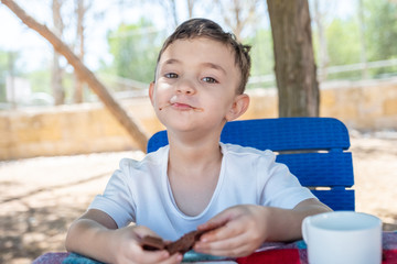 Littile arabic boy enjoying eating chocolate by him self