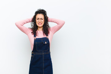 young pretty woman feeling stressed, worried, anxious or scared, with hands on head, panicking at...