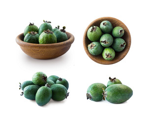 Green feijoa fruits in a wooden bowl isolated on white background. Top view. Fruits from different angles on white. Set of feijoa fruits.
