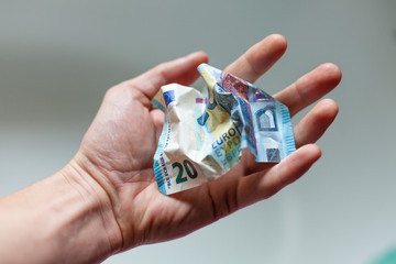 20 Euro Geldschein liegt zerknittert in der Hand gehalten