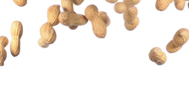 peanuts flying in super slow motion on white background