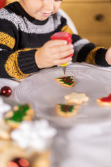 Cute child decorating cookies on Cristmas time