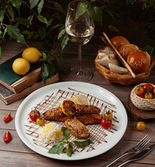 grilled salmon and chicken lula kebab with rice, tomato,lemon