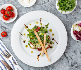vegetable salad with sundried tomato, pesto sauce, arugula, breadstikcs, fresh tomatoes, parmesan