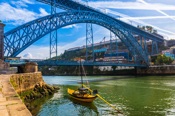 Boat in front of the Dom Luis I bridge on the Douro River in Porto, Portugal