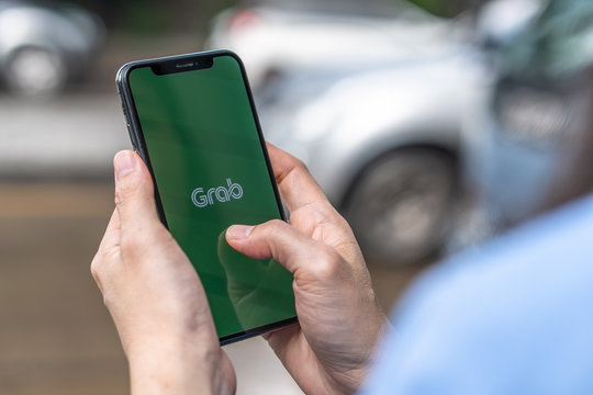 BANGKOK, THAILAND - October 12, 2019: Grab app, application on smartphone on street traffic for calling, Grabbike (win), Grabtaxi, Grabcar, Grabexpress (delivery), Grabfood (Food delivery) service