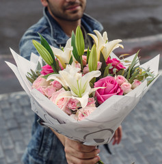 man holding white lilium bouquet with pink roses